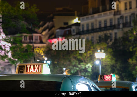 Taxi Schild auf dem Dach eines Autos in der Nacht in Lissabon. Stockfoto