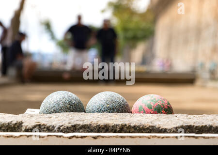 Nahaufnahme von Boccia Kugeln im Freien mit verschwommenen Spieler in Saint-Malo, Frankreich. Stockfoto