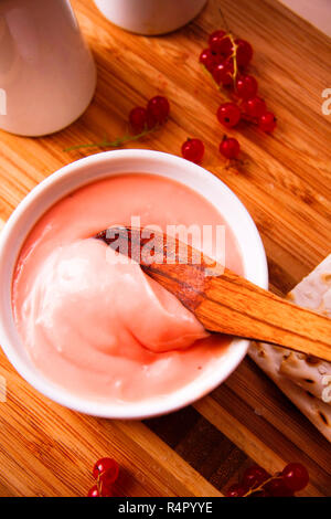 Johannisbeere Creme oder Quark in Schüssel auf Holzbrett Stockfoto