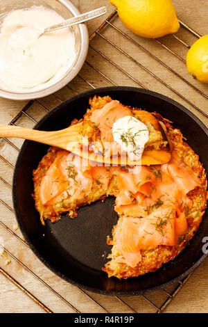 Kartoffel-Pizza mit Lachs und Sahne in schwarze Pfanne Stockfoto