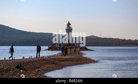 Wladiwostok, Russland - 11. SEPTEMBER 2018: Tokarevsky Leuchtturm und Menschen Besucher während einer internationalen Segelregatta vor dem Hintergrund der Stockfoto