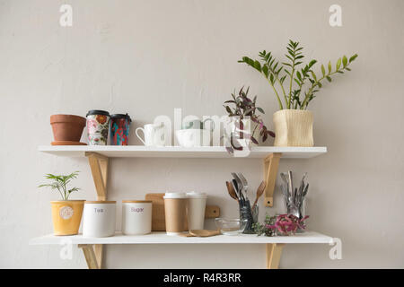 Töpfe und Geschirr in den Regalen Stockfoto