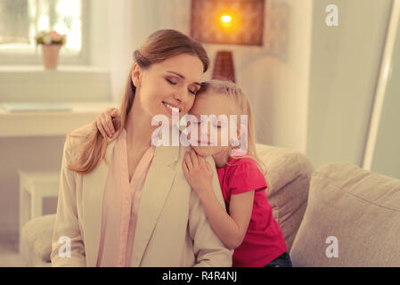 Angenehme ruhige Mutter und Tochter ihre Augen schließen Stockfoto