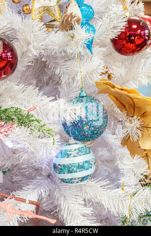 Fragment eines weißen geschmückten Weihnachtsbaum mit zwei blauen Kugeln Stockfoto