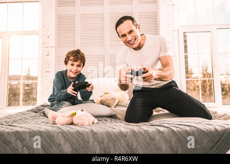 Kleiner Junge mit einem verrückten Abend Spiele spielen mit seinem Vater. Stockfoto