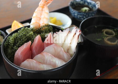 Sushi-Sashimi vom Thunfisch, Garnelen und Tintenfisch auf schwarzem Teller Stockfoto