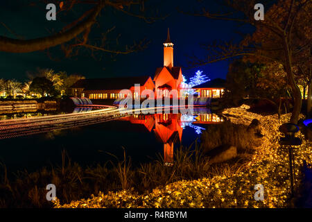 Nabana keine Sato Blumengarten, Winter Beleuchtung. Leuchten Kapelle durch den Teich. Sehenswürdigkeiten von Nagoya. Stockfoto