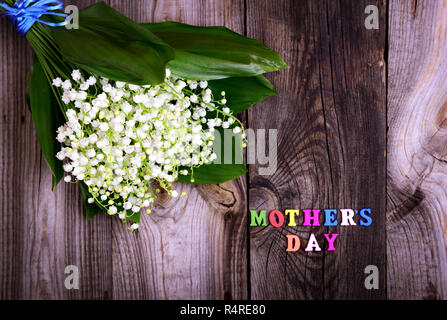 Blumenstrauß aus weißen Lilien auf das Tal auf einem grauen Holz- Oberfläche Stockfoto