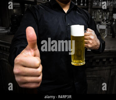 Der Barkeeper, ein Daumen hoch, ein Bier Stockfoto