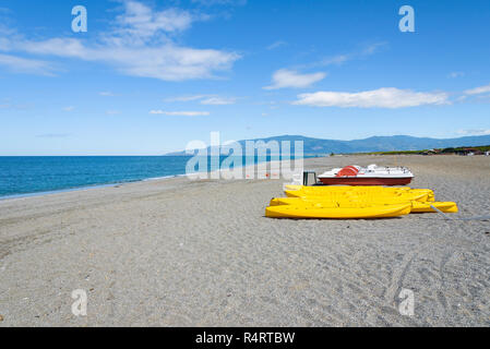 Tretboote und Kajaks auf eine Kies Strand am Tyrrhenischen Meer in Kalabrien, Italien Stockfoto