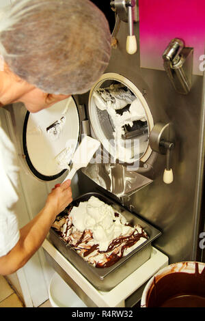 Frau Koch und Mitarbeiter arbeitet an Ice Cream Factory ist die Reinigung ice cream maker Maschine aus dem Eis gatterabraum. Vorbereitung von Eis. Stockfoto