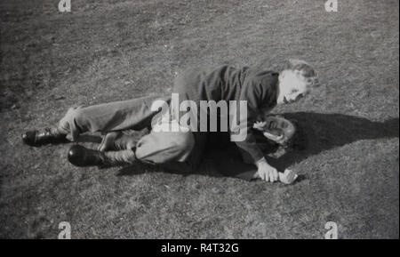 1950, historische, zwei Schüler Spaß, eine grobe und Wäschetrockner mit einander, eine spielerische tussel auf dem Boden, England, UK. Stockfoto