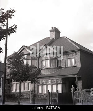 1940, historische, eine Dame am Eingang eines halb-freistehende zweistöckige Haus Suburban House, England, UK. In den 1920er Jahren gebaut, das Haus hatte Holzkiste, Kastenfenster und Pebble Dash Exterieur. Stockfoto