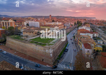 Antenne Panorama der beliebten Reiseziel Stadt am Strand Fano in Italien mit Sonnenuntergang Blau, Rot, Lila Himmel in der Nähe von Rimini, in der Region Marche. Stockfoto