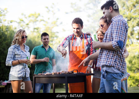 Freunde genießen bbq Party und lächelnd in der Natur Stockfoto