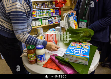 Food Bank Chichester freiwilligen Helfer stellt die Bedürftigen, Armen Menschen mit gespendeten Lebensmitteln in der Familie Kirche und Sortieren und das Essen in Ihrer Nahrung Depot lagern. Stockfoto