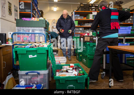 Food Bank Chichester freiwilligen Helfer stellt die Bedürftigen, Armen Menschen mit gespendeten Lebensmitteln in der Familie Kirche und Sortieren und das Essen in Ihrer Nahrung Depot lagern. Stockfoto