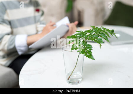 Asiatischen Unternehmer Buch zu lesen, während der Kaffeepause mit Schwerpunkt Pflanze. Stockfoto