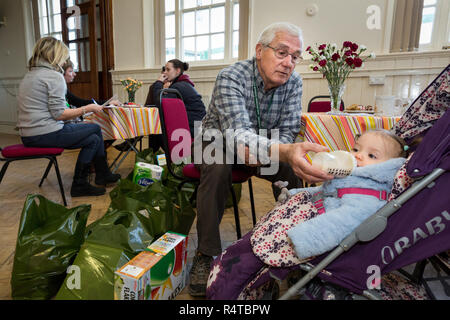 Food Bank Chichester freiwilligen Helfer stellt die Bedürftigen, Armen Menschen mit gespendeten Lebensmitteln in der Familie Kirche und Sortieren und das Essen in Ihrer Nahrung Depot lagern. Stockfoto