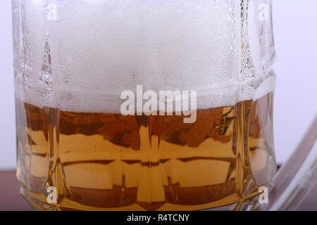 Becher frisches Bier mit Kappe aus Schaumstoff Nahaufnahme Stockfoto