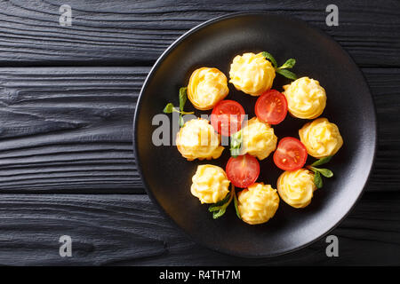 Appetitliche Snacks Herzogin Kartoffeln closeup auf eine schwarze Platte auf einem Holztisch. horizontal oben Ansicht von oben Stockfoto