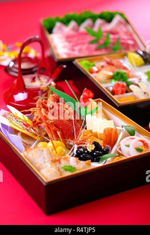 Bento von frischen Meeresfrüchten mit Hummer, Thunfisch, Garnelen und Muscheln auf rotem Grund Stockfoto