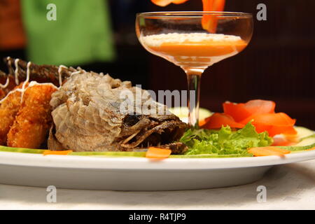 Gebratener Schlange Kopf Fisch mit Sauce und Salat auf weiße Schale Stockfoto