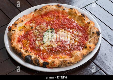 Heiße leckere Pizza mit Champignons und Tomaten auf weißem Teller Stockfoto