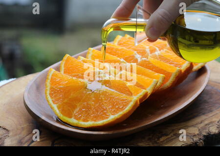 Oilling in Scheiben geschnitten Orange auf schwarzem Teller Stockfoto