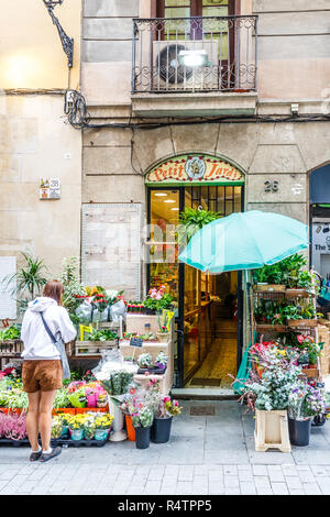 Barcelona, Spanien - 4. Oktober 2017: Frau außerhalb eines Floristen shop, La Rambla. Das Gebiet hat viele kleine Fachgeschäfte. Stockfoto