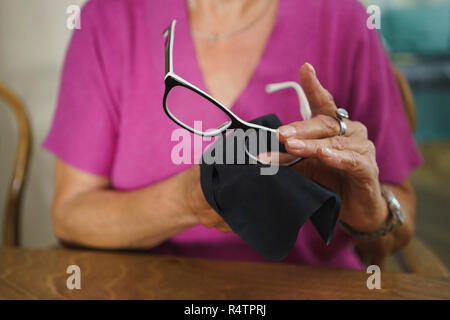 Ältere Frau Reinigung Brillen Stockfoto