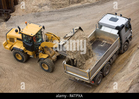 Radlader befüllen Sand auf einem Lkw Stockfoto