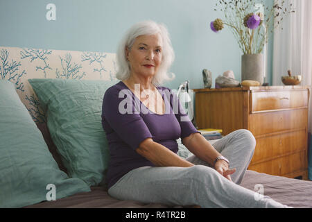 Portrait zuversichtlich ältere Frau auf dem Bett entspannen Stockfoto