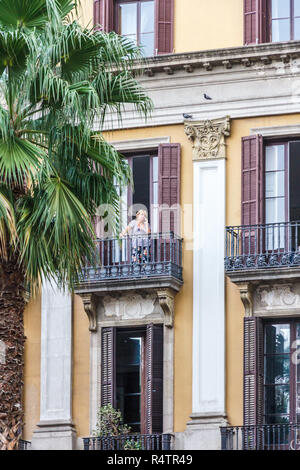 Barcelona, Spanien - 4. Oktober 2017: Mann stand auf dem Balkon auf Handy in Placa Reial von La Rambla. Das Quadrat ist beliebt für Ess- und nig Stockfoto