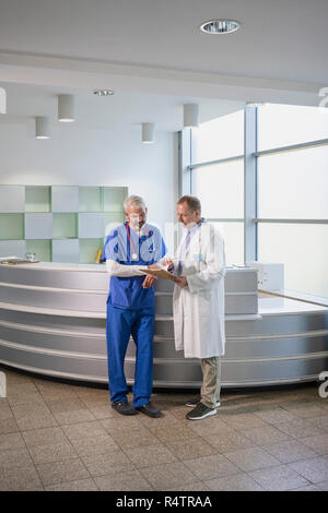 Männliche Ärzte diskutieren medizinische Aufzeichnung im Krankenhaus Stockfoto