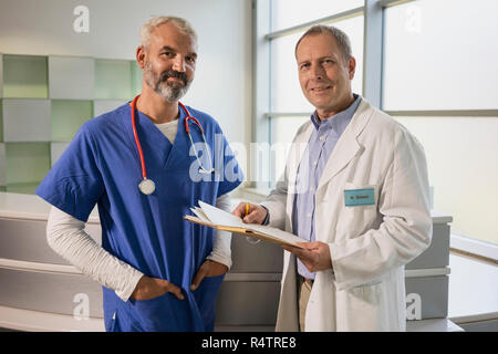Portrait zuversichtlich männlichen Ärzten mit medizinischen Aufzeichnung im Krankenhaus Stockfoto