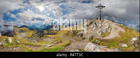 360° Bergpanorama von Hochiss Gipfel mit Gipfelkreuz und bizarre bewölkter Himmel, Rofangebirge, Achensee, Maurach, Tirol Stockfoto