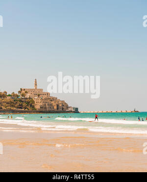 Surfer am Strand, Alma Strand entfernt, hinter der Altstadt von Jaffa mit der Kirche St. Peter, den alten Hafen, Tel Aviv-Jaffa, Israel Stockfoto