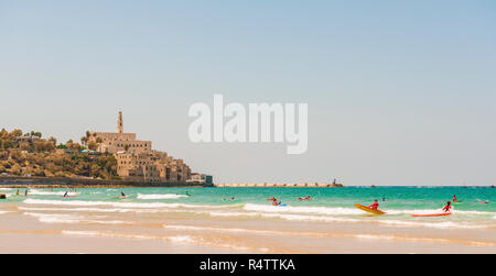 Surfer am Strand, Alma Strand entfernt, hinter der Altstadt von Jaffa mit der Kirche St. Peter, den alten Hafen, Tel Aviv-Jaffa, Israel Stockfoto