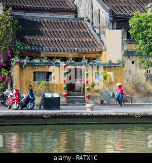 Traditionelle vietnamesische Dame mit dem Fahrrad in die Altstadt von Hoi An Vietnam. Stockfoto