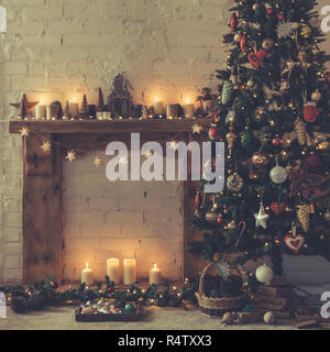 Schöne Weihnachten Zimmer, dekoriert mit Kamin mit Massivholz Kaminsims, beleuchtete Weihnachtsbaum mit Flitter Ornamente, Sterne, Weihnachtsbeleuchtung Stockfoto