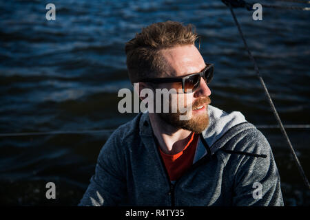 Porträt einer stilvollen Fisher Mann, der ein Motorboot im Sonnenuntergang. Stockfoto