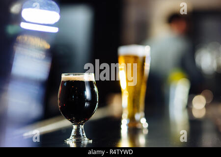 Gläser Bier sitzen auf einem Balken oben in einem Handwerk Brew Pub Stockfoto