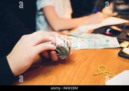 Männliche Hand hält einen dicken Stapel von Bargeld. Millionen russischer Rubel. Das Konzept der Reich, Reichtum, Gewinne, Business und Finanzen. Fünf tausendstel Rechnungen Banknoten. Eine lose Bündel von Geld. Stockfoto