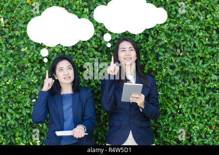 Zwei business Frauen suchen und denken über Ziele mit leeren Blasen. Stockfoto