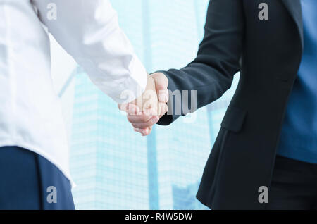 Geschäft Leute die Hände schütteln, bis Beendigung einer Versammlung mit modernen Gebäude im Hintergrund. Stockfoto