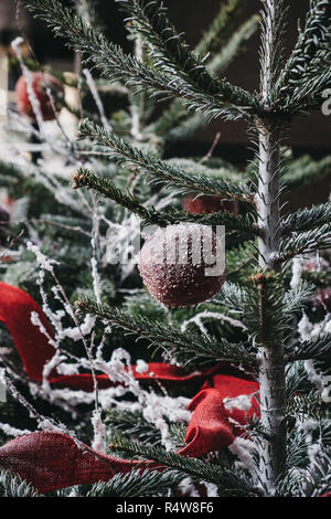 In der Nähe von Weihnachten Dekorationen auf einer echten snowy christmas tree. Stockfoto