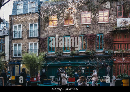 London, UK, November 21, 2018: die Menschen unter die Weihnachtsbeleuchtung in Neal's Yard, Covent Garden, London. Covent Garden ist ein berühmtes Touristenzentrum von Lon Stockfoto