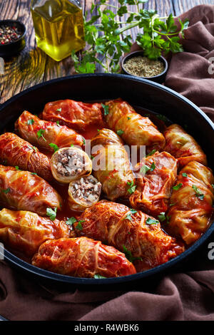 Kohlrouladen gefüllt mit Hackfleisch und Reis und gebackene in Perfektion mit einer würzigen Tomatensauce in einem holländischen Ofen, vertikale Ansicht von oben, close-up Stockfoto