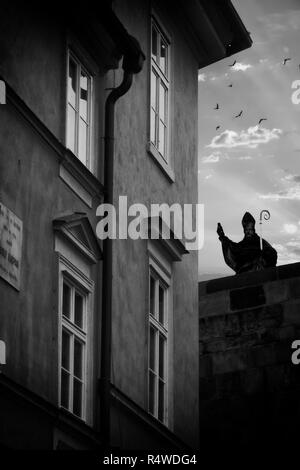 Suggestive Bild einer Statue auf der Karlsbrücke in Prag eine Illusion der mystische Erscheinung vor einem Haus Stockfoto